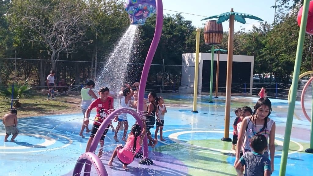 kids playing on splash pad - purple dragon shooting water