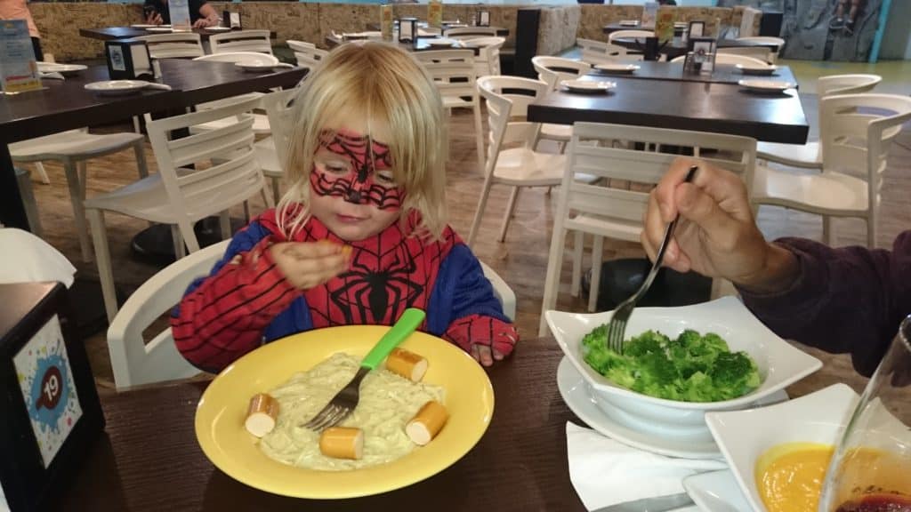 kid dressed as Spiderman eating mac and cheese