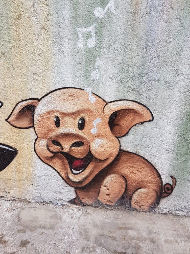 cartoon pig with musical notes coming out mouth. painted on a wall