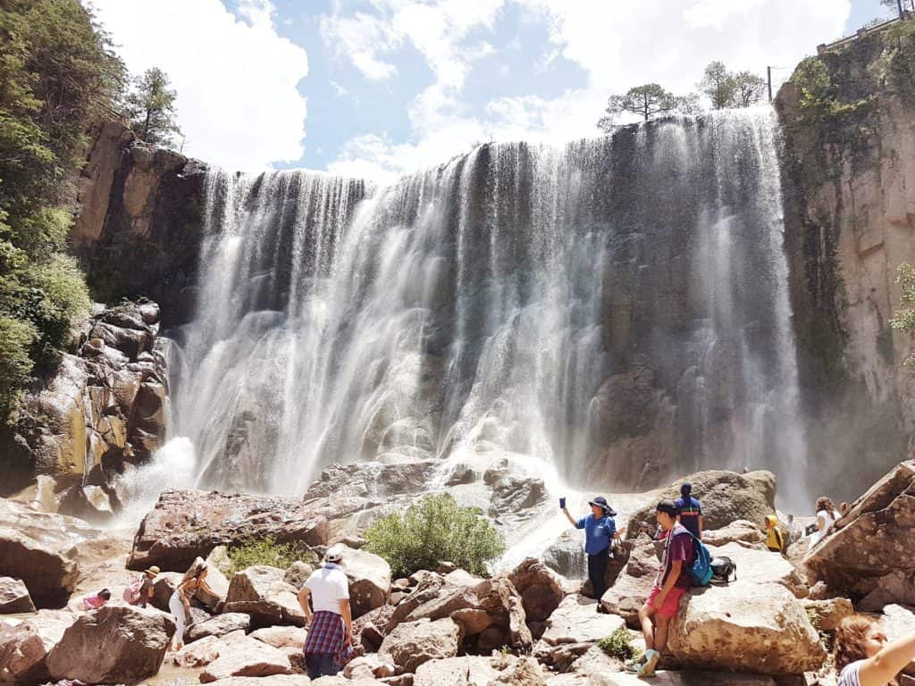 view from bottom of waterfall. people in foreground