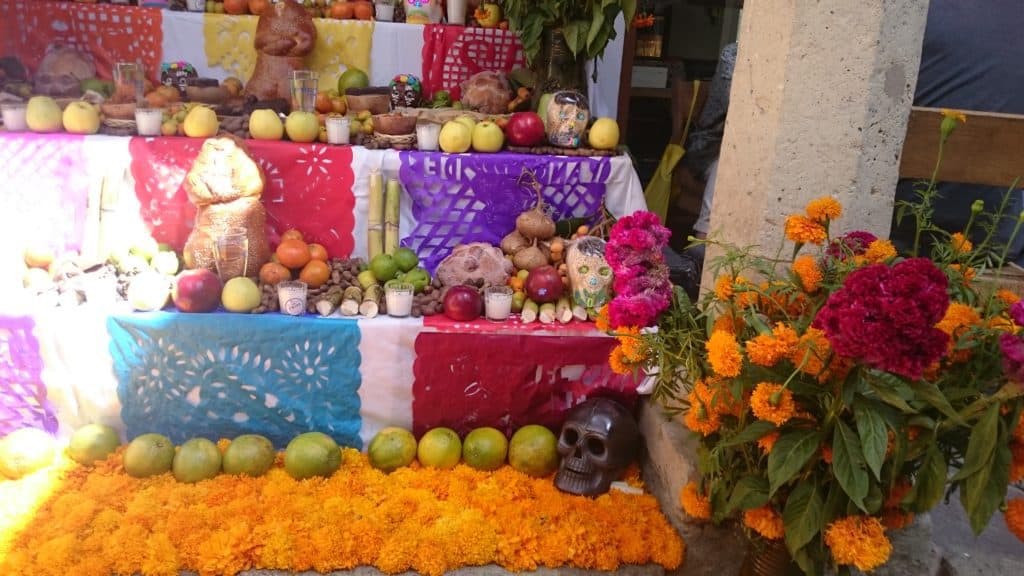 altar with paper cuts, marigolds and offerings