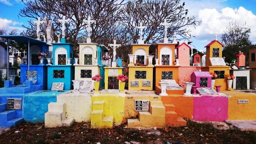 collection of small colourful graves with crosses on top
