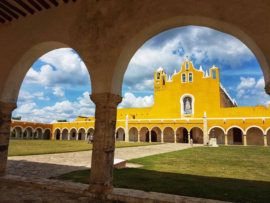 Izamal convent in all its yellow glory seen through arches