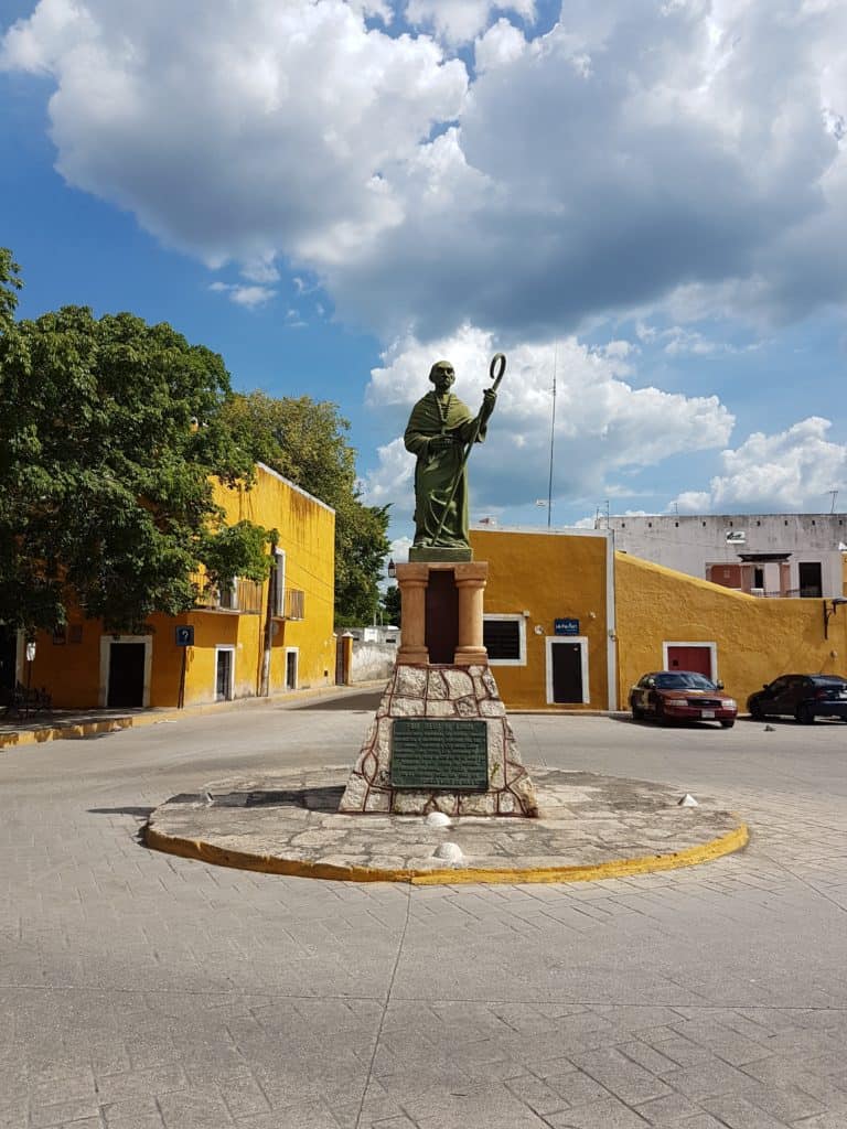Frey Diego de Landa statue on a roundabout in Izamal (yellow buildings)