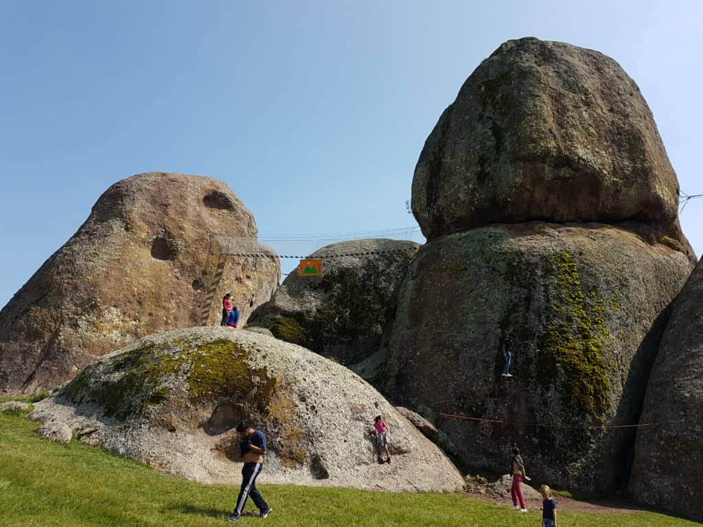 huge rocks, people walking around. via ferrata course