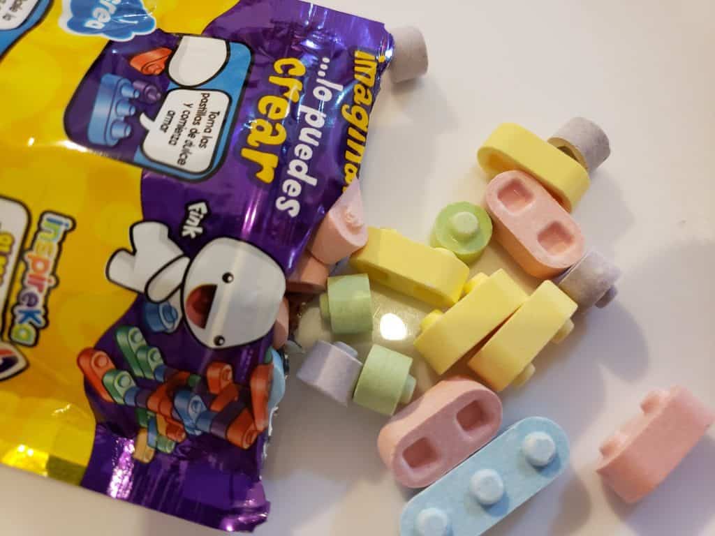 open coloured packet with individual coloured candies shaped like round lego
