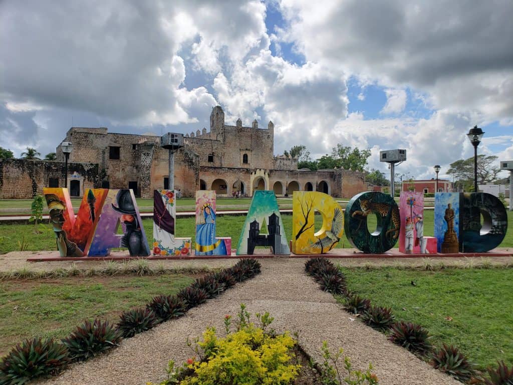 Valladolid coloured city letters, grass in foreground, convent in background