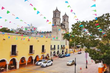 view of valladolid cathedral and yellow building next to it. colourful bunting