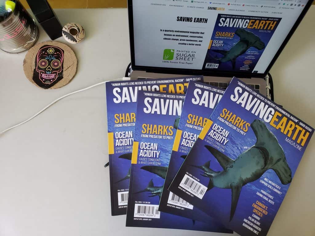 four magazine on a computer. Magazine is called Saving Earth and has a shark on cover