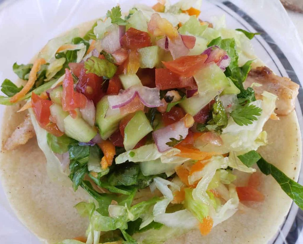 close up of a fish taco covered in salad