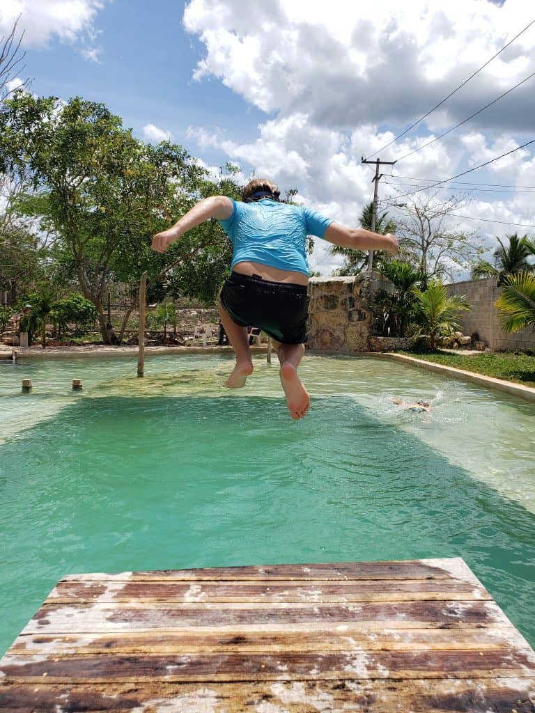 kid in blue jumping into a pool