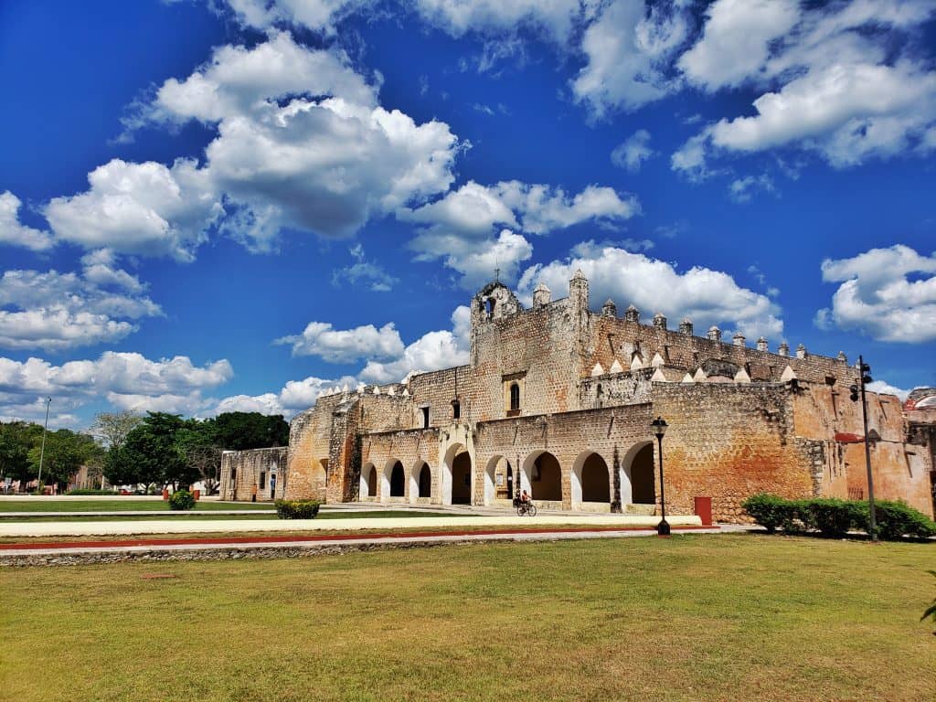 ex monestary, green grass in front, arches and blue sky