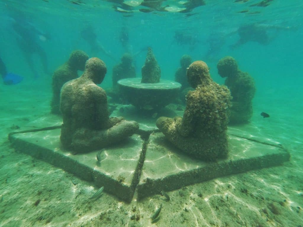 underwater sculptures, people sitting around a table