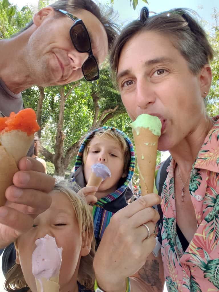 two adults two children all eating brightly coloured ice creams