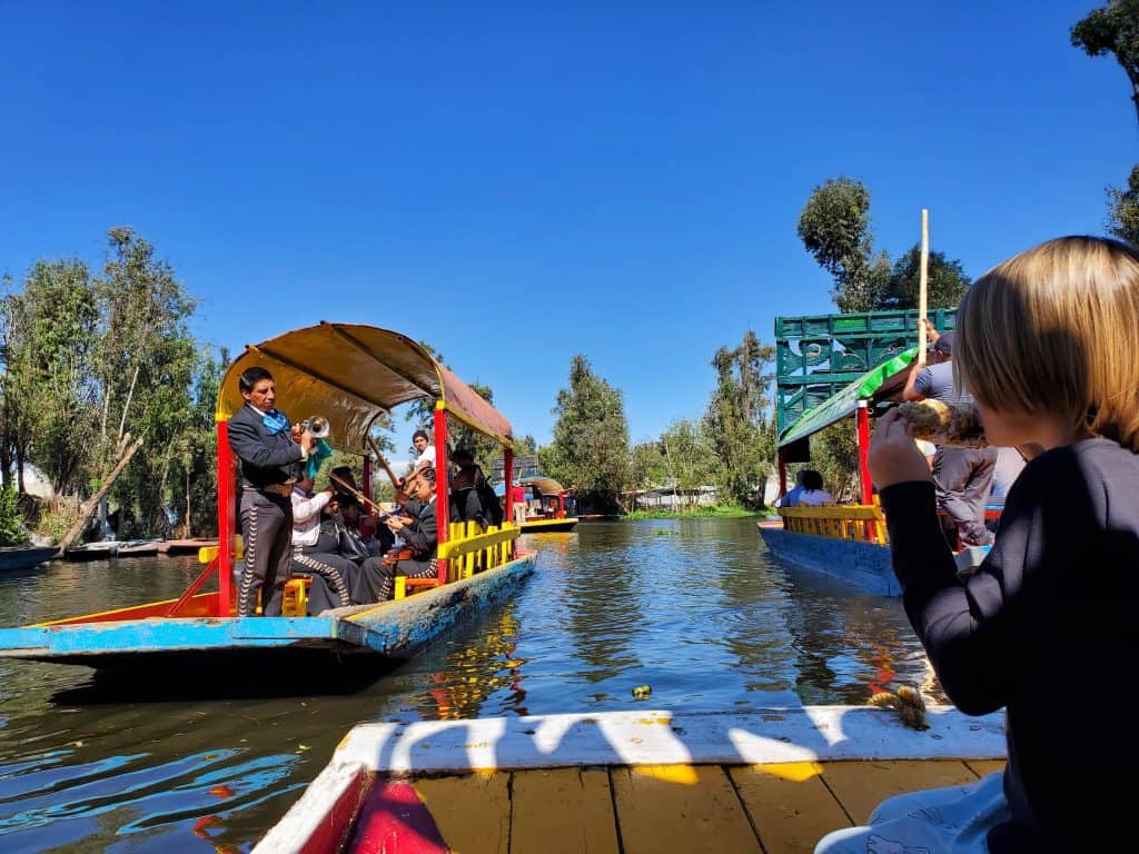 long mexican canal boats, very colourful, one with mariachis on 