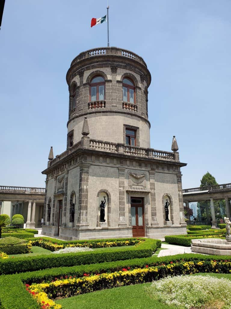 observatory - cube building bottom floor and round two storey tower on top. ornamental bushes around and blue sky