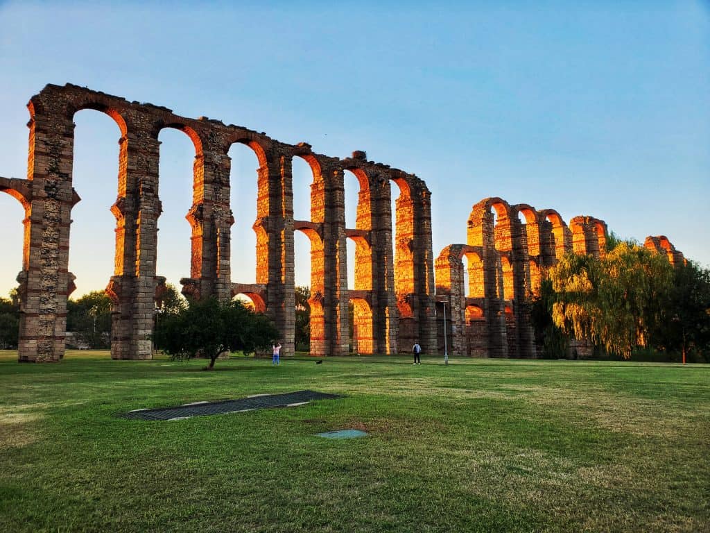 section of ruined aqueduct, lit by setting sun