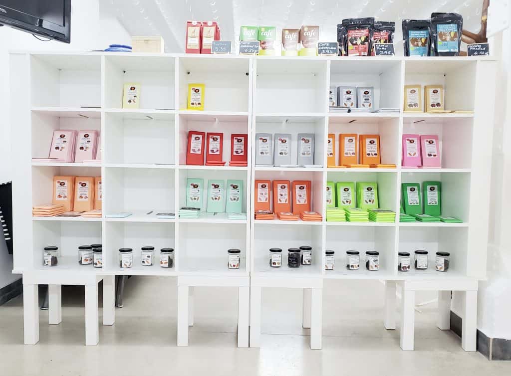 white shelves with colourful bars of chocolate standing upright in them