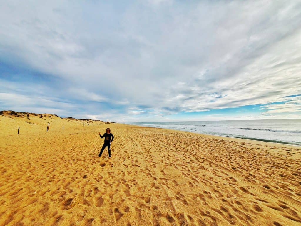 empty wide beach. one person posing on sand