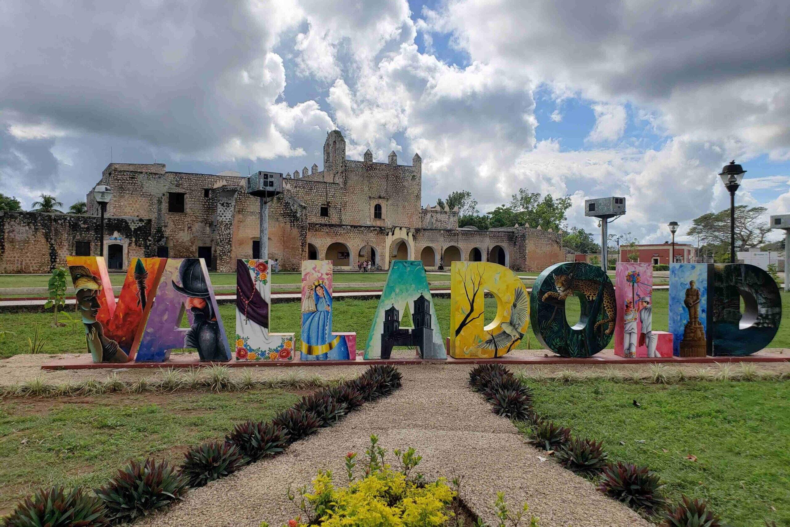 Valladolid coloured city letters, grass in foreground, convent in background