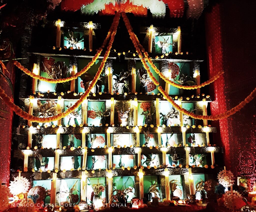 dark photo. Day of the Dead altar consisting of many boxes with photos and candles.