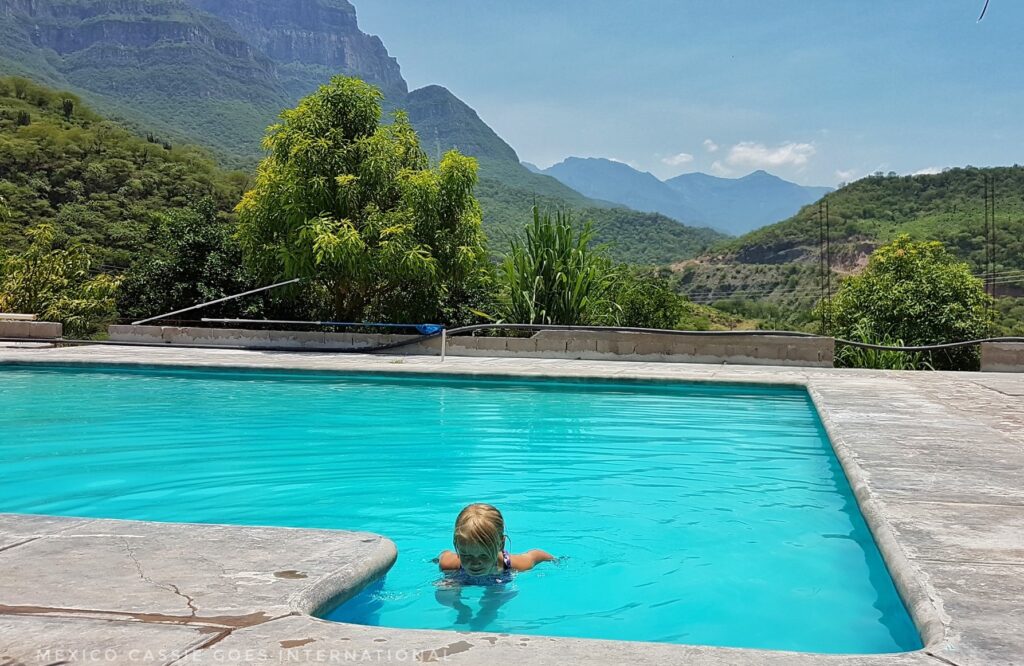 child in a bright pool, mountains in background