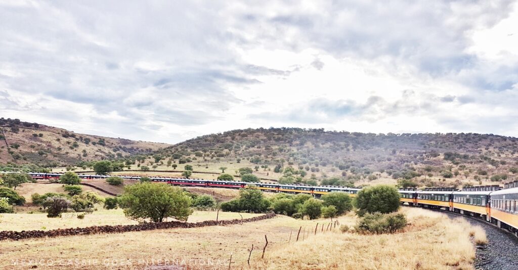 long train winding around track through countryside