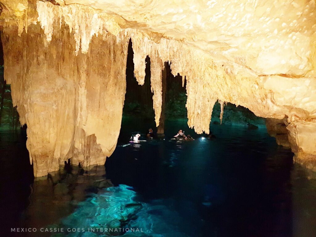 dark cave filled with water, green light from under the water