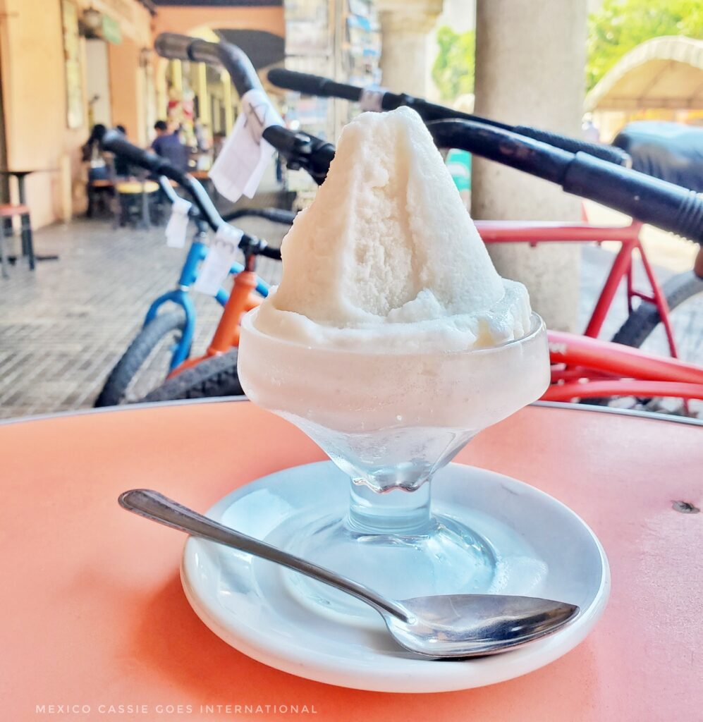 ice cream from colon in merida. white cone shaped ice cream in a glass bowl. bikes in background