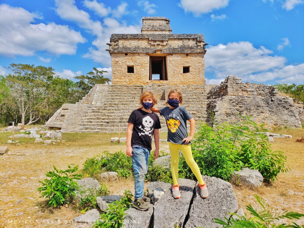 two children standing in front of the dolls' house - building at dzibilchaltun mayan ruin