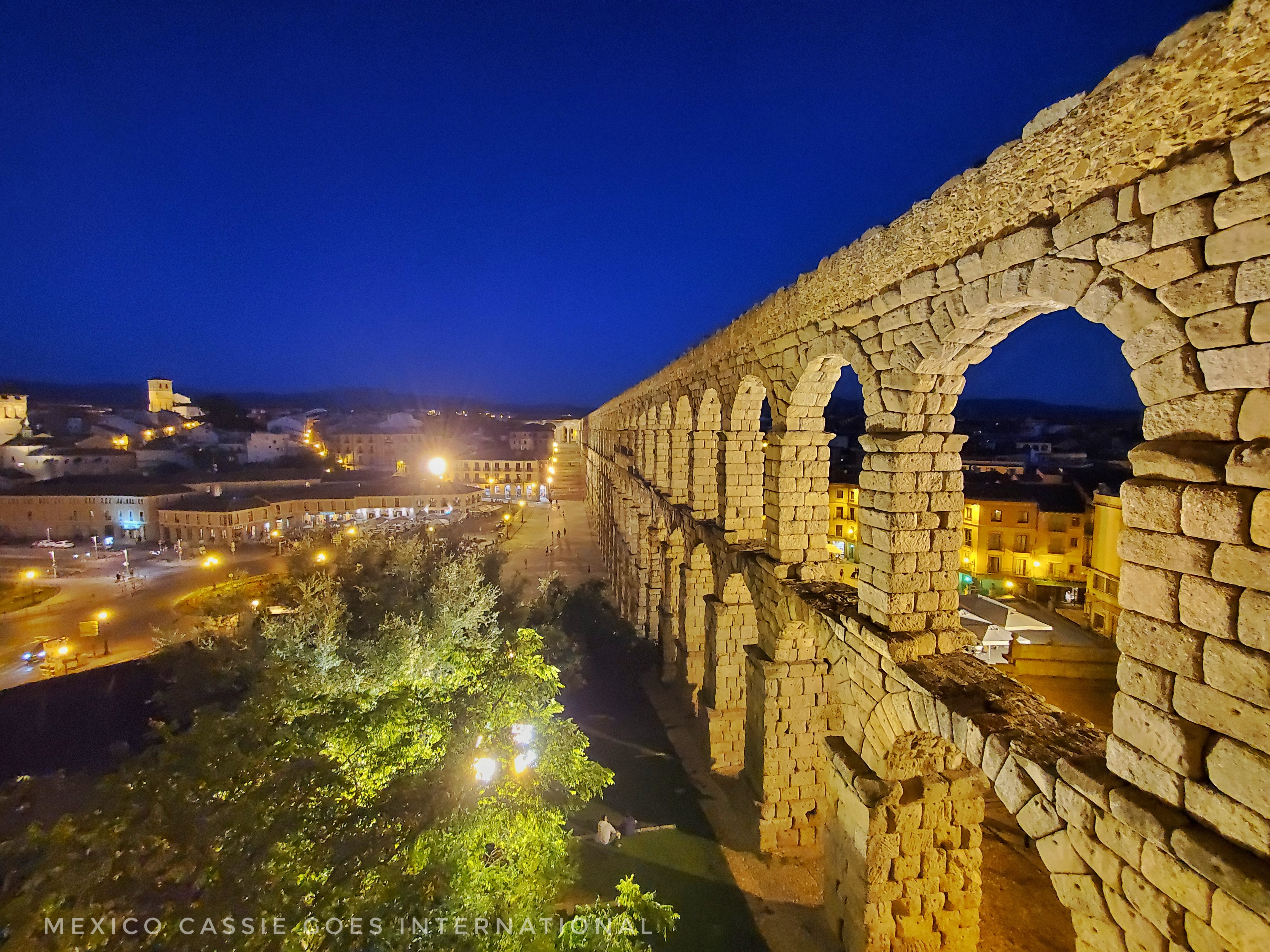 2 storey aqueduct at night. arches are lit yellow and are on right of photo heading into distance