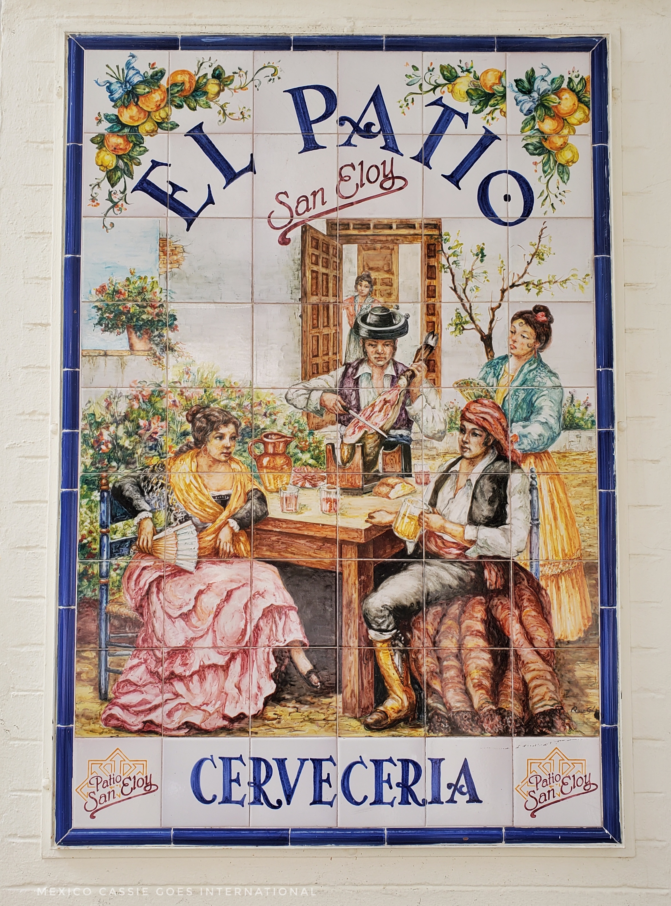 tile wall poster  - writing says, EL Patio and Cerveceria. Picture is of 19thcentury people around a table