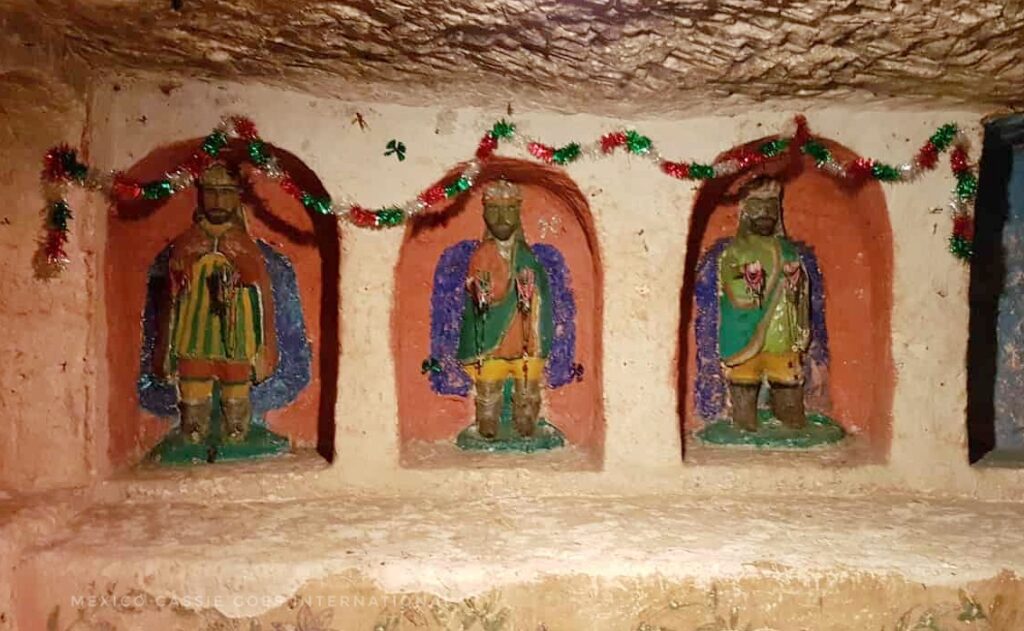 three alcoves each with a carving of a king inside. tinsel hanging over (red, green, white)