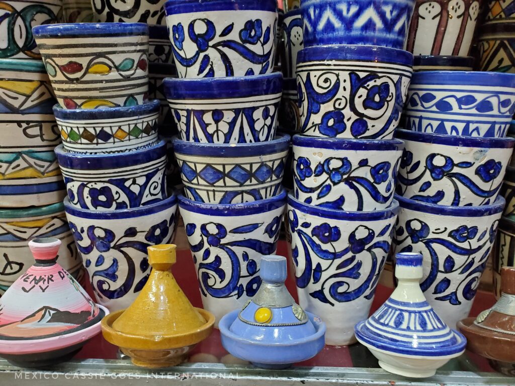 stacks of white and blue bowls. small tagine pots in single row at front