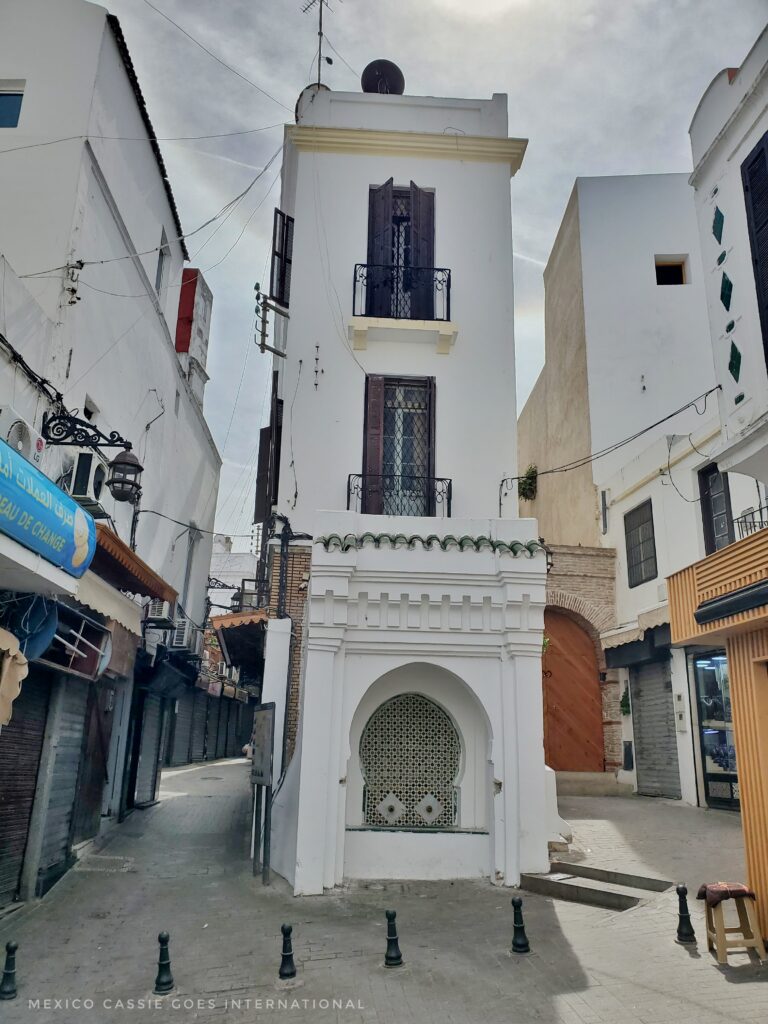 narrow 3 storey building. with street and buildings on either side