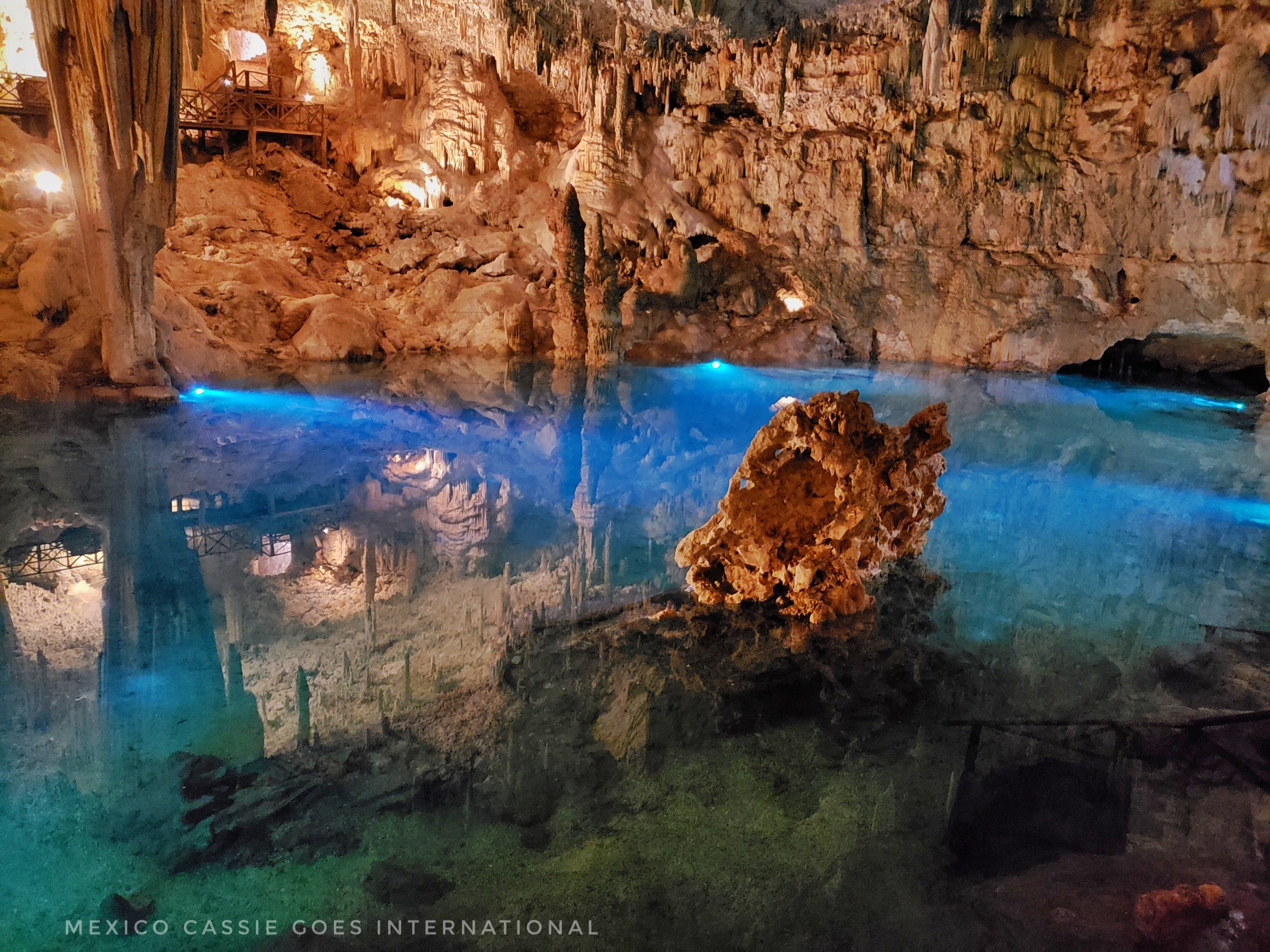 zazil tunich cenote - clear blue water with rocks and reflection of rocks in water