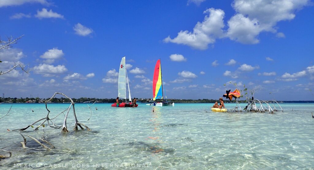 shallow clear water, three boats on water