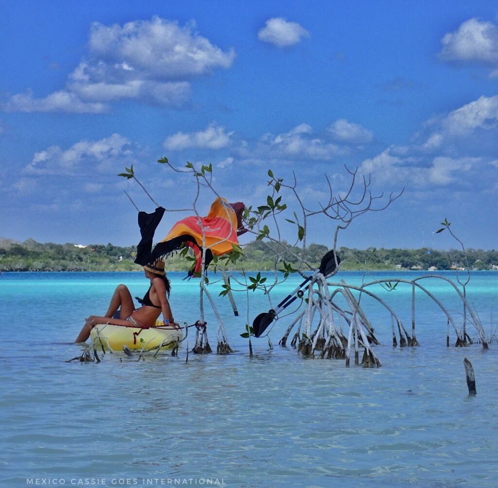 woman sitting on yellow kayak in beautiful shallow water