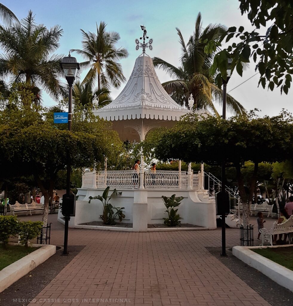 white town square gazebo surrounded by palm trees