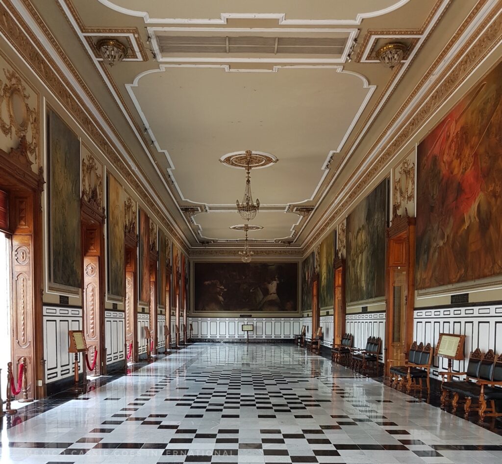 view of a room full of murals in the merida palacio de gobierno - black and white tiled floor