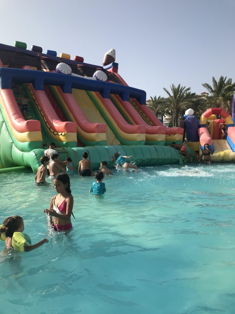 inflatable slides into water, kids playing