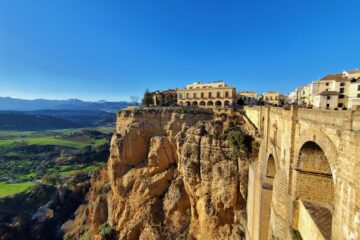 view of ronda's puente nuevo from one side. can see bluff and town on top and into valley below