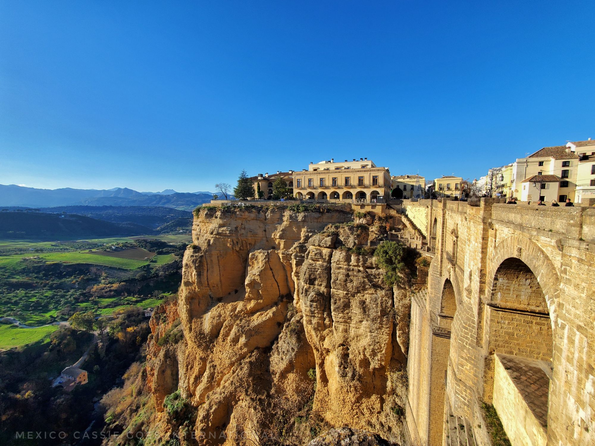 view of ronda's puente nuevo from one side. can see bluff and town on top and into valley below