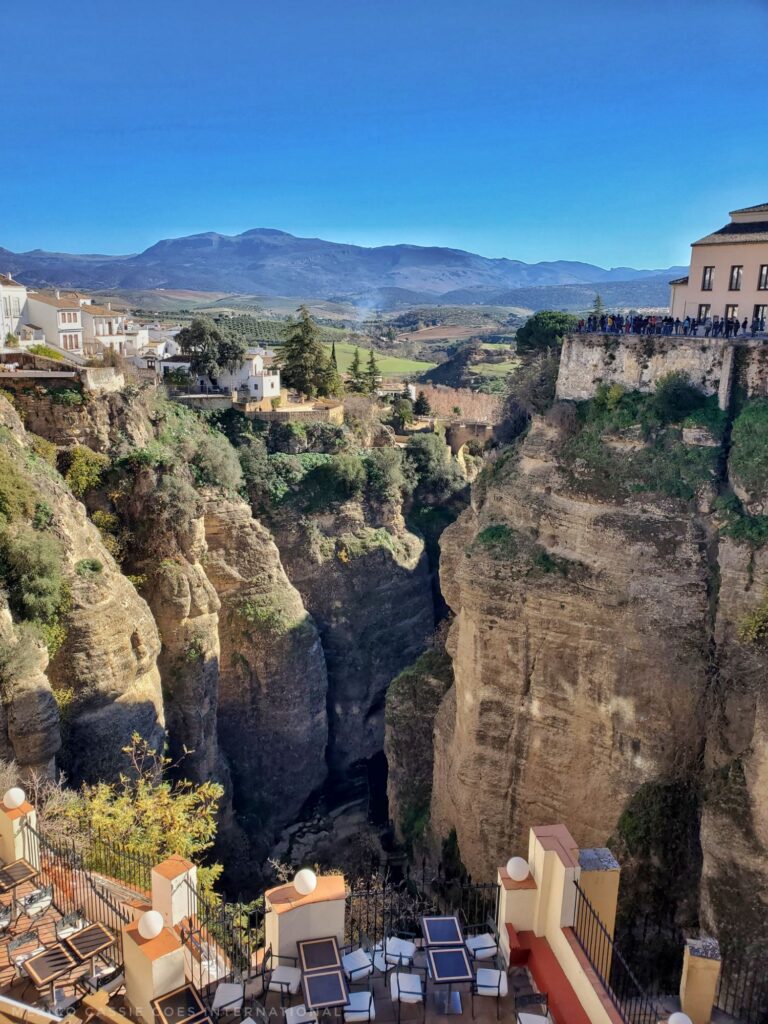 view along the gorge at ronda - cafe tables below