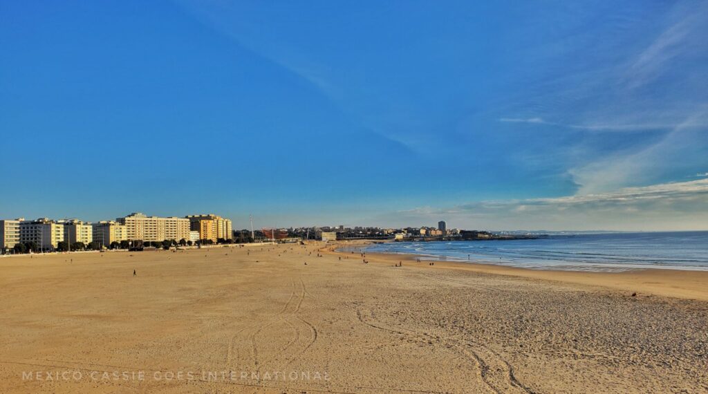 empty sandy beach, buildings in distance