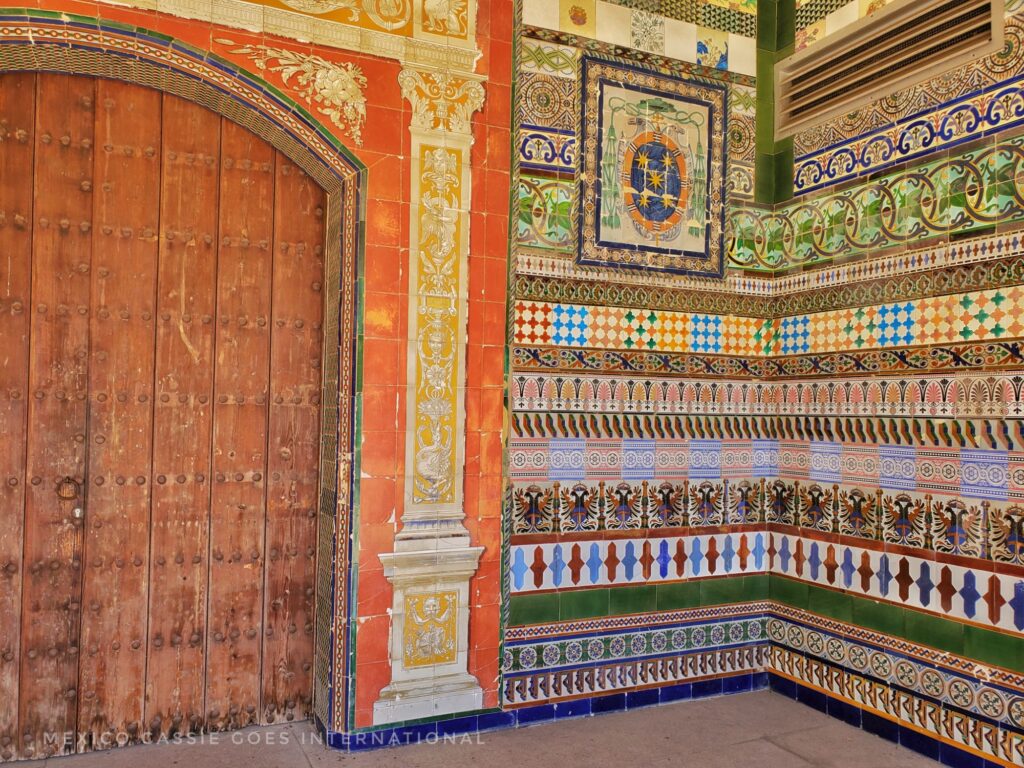 wooden door and rows of tiles on the wall, each row is of a different pattern