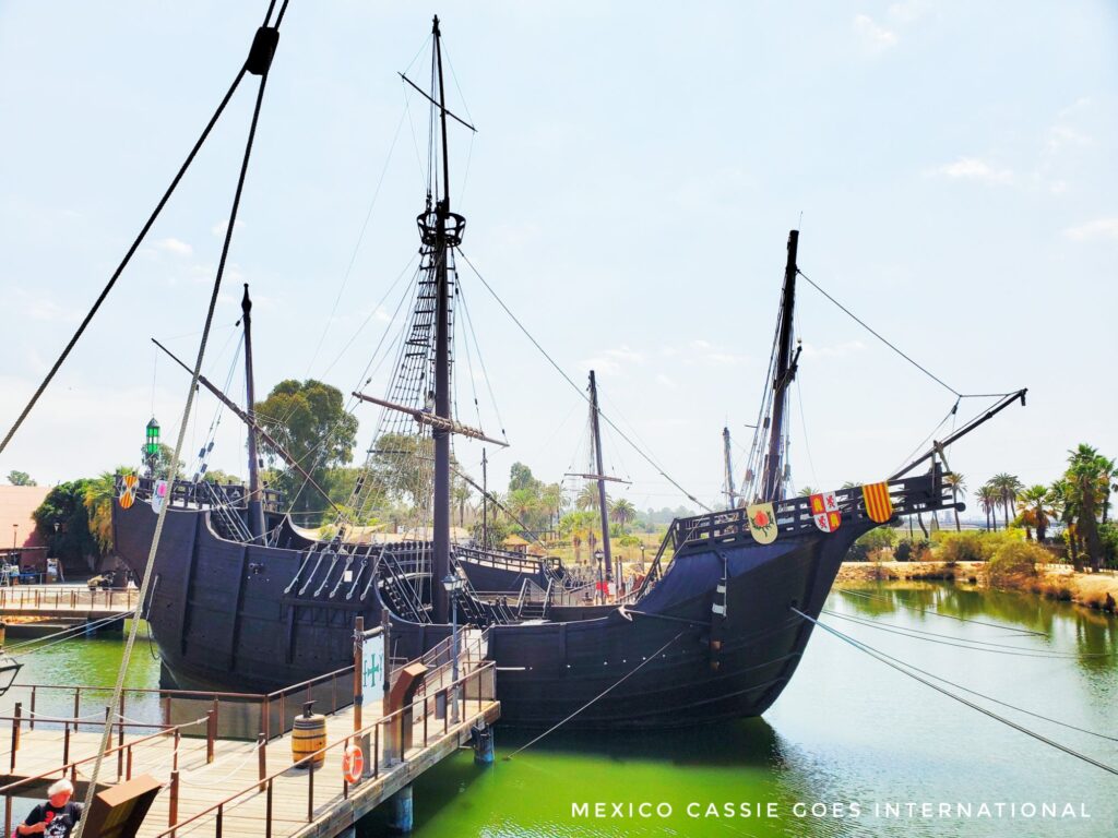 replica of one of Columbus' ship sitting on green water