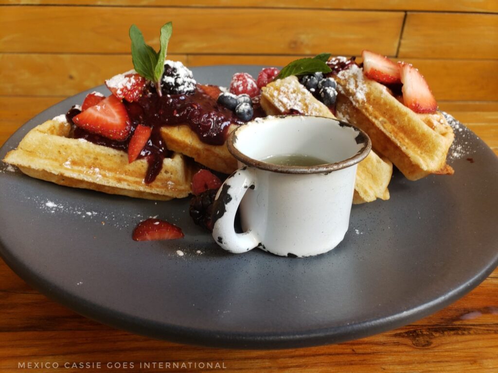 plate of waffles covered in fruit