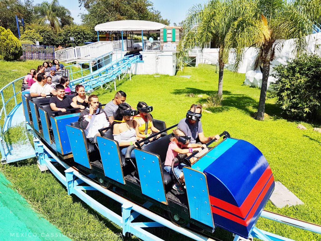 small blue rollercoaster. everyone on it is wearing a 3d headset
