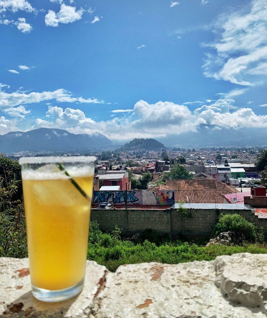 beer with ice in it on a wall - view over town and mountains